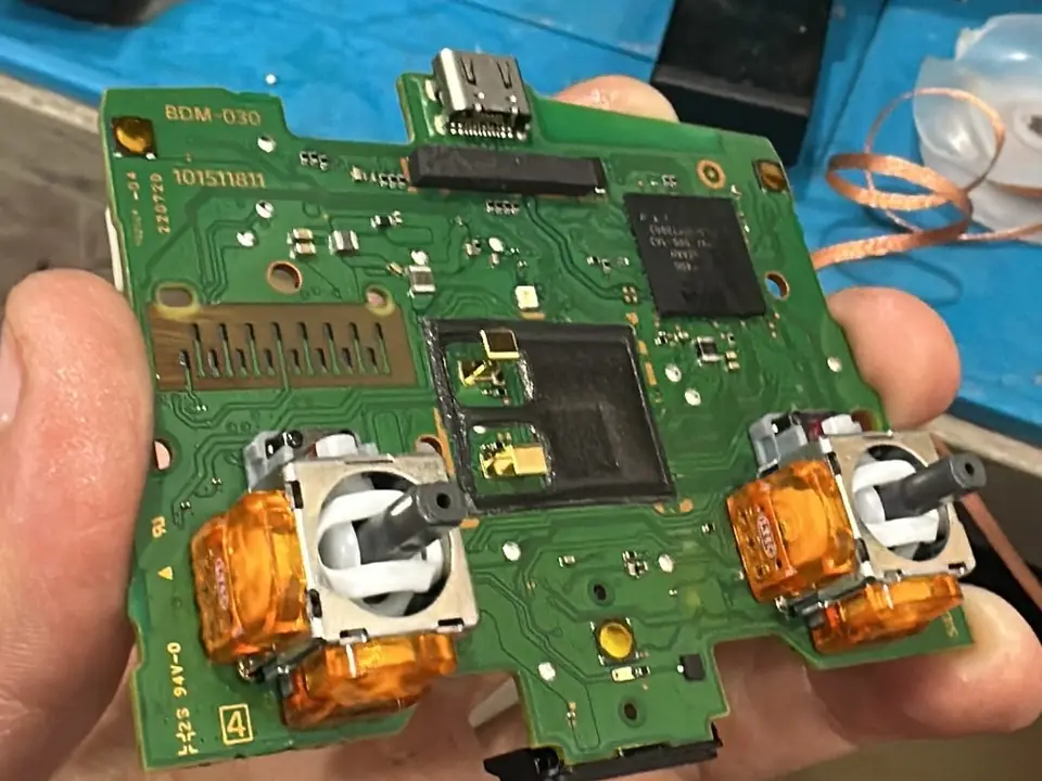 Placa de un mando DualSense con los dos joysticks magnéticos ya soldados, en el taller de Easy Tech